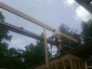 Carpenter setting a ridge beam over a new addition frame — Ice Dam Removal by Roofing Brothers in Mc Kenzie