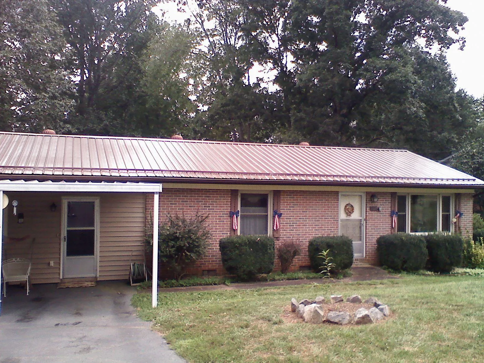 Bronze metal roof and carport on a brick ranch home — Roof Repair work by our crew in Mc Kenzie