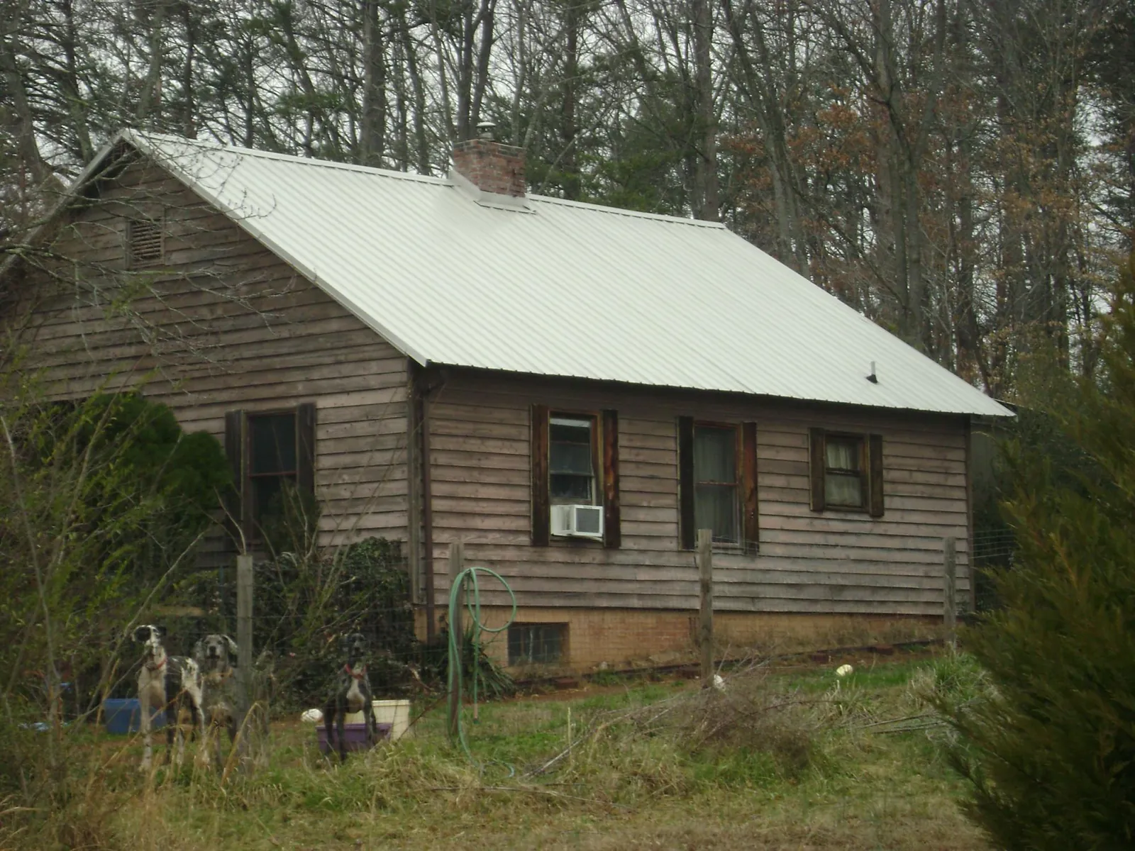 White metal roof on an old wood sided farmhouse, from a Metal Roof Installation job in Mc Kenzie